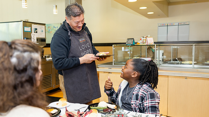 Man Serving Meal to Child